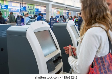 NEW YORK - MARCH 22, 2016: woman use check-in kiosk in JFK airport. John F. Kennedy International Airport is a major international airport located in Queens, New York City, United States.