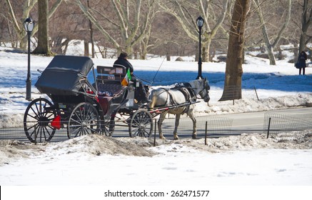 NEW YORK - MARCH 9, 2015: People Enjoying Classical A Horse And Carriage Ride In Central Park, New York City After A Winter Storm, With Snow Still On The Ground