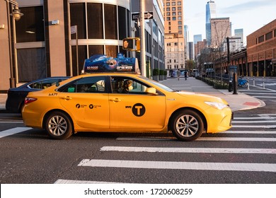 NEW YORK, NEW YORK - MAY 02, 2020: A New York City Taxi Cab Driver Wearing A Face Mask While Driving In Lower Manhattan During The COVID-19 Coronavirus Pandemic.