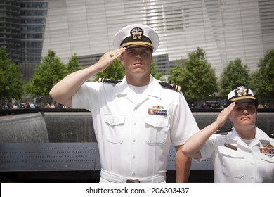 NEW YORK - MAY 23, 2014: Two US Navy Sailors Standing In Front Of The Reflecting Pools At The National September 11 Memorial Site Salute During The Re-enlistment And Promotion Ceremony.