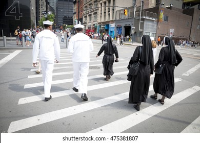 NEW YORK MAY 27 2016: US Navy personnel and Catholic nuns walk across Greenwich St after the re-enlistment and promotion ceremony at the National September 11 Memorial site during Fleet Week 2016. 