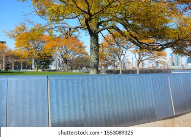 NEW YORK, NY - 04 NOV 2019: The American Immigrant Wall Of Honor At Ellis Island, With Colorful Fall Trees. Colorful, 