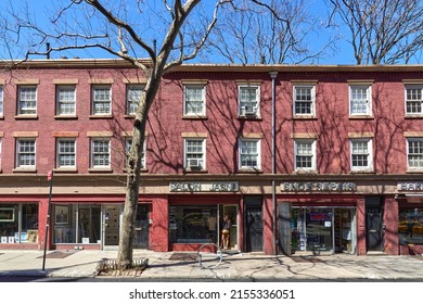 New York, NY - April 15, 2022: A Row Of 3-story Red Brick Houses (1836) With Storefronts On West 10th Street In Greenwich Village, NYC. They Are Made 1836 With Flemish Bond Brickwork Pattern.
