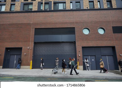 NEW YORK, NY - APRIL 20, 2020: New Yorkers Wait In Long Lines 6 Feet Apart To Get Into A Midtown Grocery Store Due To COVID19. 