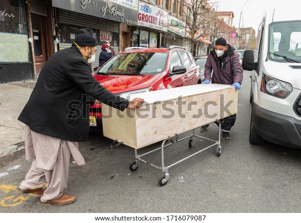 New\
York, NY - April 27, 2020: Workers of Al-Rayaan Funeral Home in\
Brooklyn where traditional Muslim rituals performed load casket for\
burial into funeral car during COVID-19\
epidemic