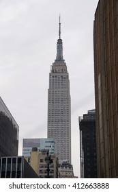 New York, NY - April 28, 2016: Vertically Framed Shot Of The Empire Statue Building On An Overcast Day Looking Past Madison Square Garden, Home Of The Rangers And Knicks.