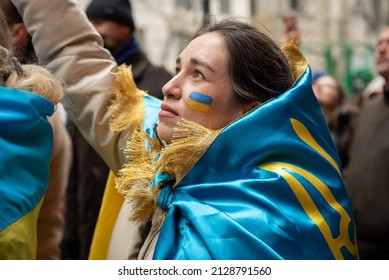 New York, NY - February 24, 2022: Woman wrapped in Ukrainian flag at a demonstration to protest Putin’s aggression and the invasion of Ukraine