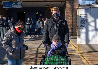 NEW YORK, NY – JANUARY 10, 2021: A Wheelchair Bound Woman Assisted By Relatives Exits The NYC Health Department Vaccine Hub At Hillcrest High School In Queens After Receiving The COVID-19 Vaccine.