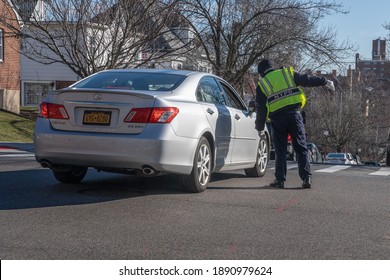 NEW YORK, NY – JANUARY 10, 2021: NYPD Police Officer Directs Traffic Outside The NYC Health Department Vaccine Hub At Hillcrest High School In Queens.