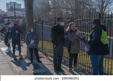 NEW YORK, NY – JANUARY 10, 2021: People Who Are Eligible And Registered Wait In Line To Get COVID-19 Vaccine At NYC Health Department Vaccine Hub At Hillcrest High School In Queens