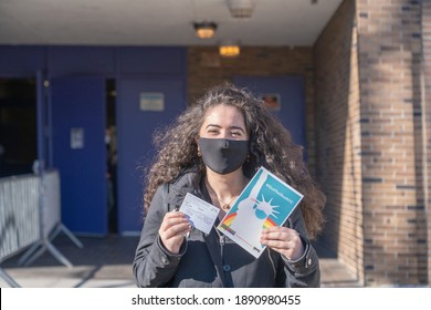 NEW YORK, NY – JANUARY 10, 2021: A Woman Displays Her Vaccination Card And The “IGotTheShotNYC” Banner After Exiting The NYC Health Department Vaccine Hub At Hillcrest High School In Queens.