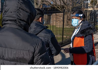 NEW YORK, NY – JANUARY 10, 2021: A Worker Verifies Eligibility And Registration Of People In Line To Get COVID-19 Vaccine At NYC Health Department Vaccine Hub At Hillcrest High School In Queens.