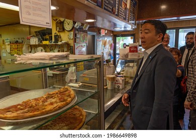 NEW YORK, NY – JUNE 06: Mayoral candidate Andrew Yang buys a pizza slice at Shimon's Pizza Restaurant during neighborhood canvassing on June 6, 2021 in New York City.