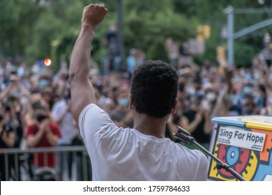 NEW YORK, NY - JUNE 19, 2020: Musician Jon Batiste speaks to gathered crowds between songs as performs live in concert on Juneteenth on the steps of the Brooklyn Public Library at the Grand Army Plaza