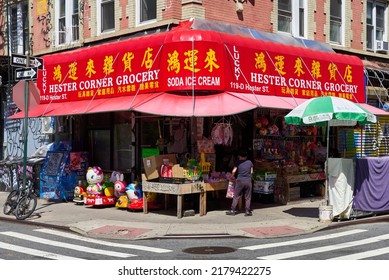 New York, NY - June 29, 2022: A Corner Grocery Store In Chinatown, NYC With A Shiny Bright Red Awning. Many Items For Sale Are On Display On The Sidewalk.
