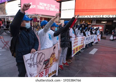 NEW YORK, NY – MARCH 13: Pro Chinese Democracy Activists Holds Banners And Raise Fists In Protest During A China Democracy Party Demonstration At Times Square On March 13, 2021 In New York City.