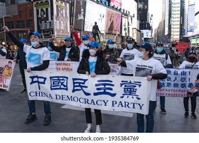 NEW YORK, NY – MARCH 13: Pro Chinese Democracy Activists Holds Banners And Raise Fists In Protest During A China Democracy Party Demonstration At Times Square On March 13, 2021 In New York City.