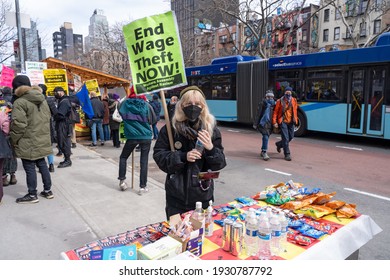 NEW YORK, NY – MARCH 6: Protester Holding Sign Gets Free Snack And Water From The People Bodega During A Protest Of Liox Cleaners On March 6, 2021 In New York City.