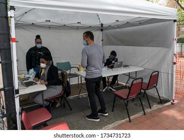New York, NY - May 18, 2020: Staff members work on computers on patients tested for COVID-19 information. Test is sponsored by UJA-Federation and Brightpoint Health in Goble Playground, the Bronx - Shutterstock ID 1734731723