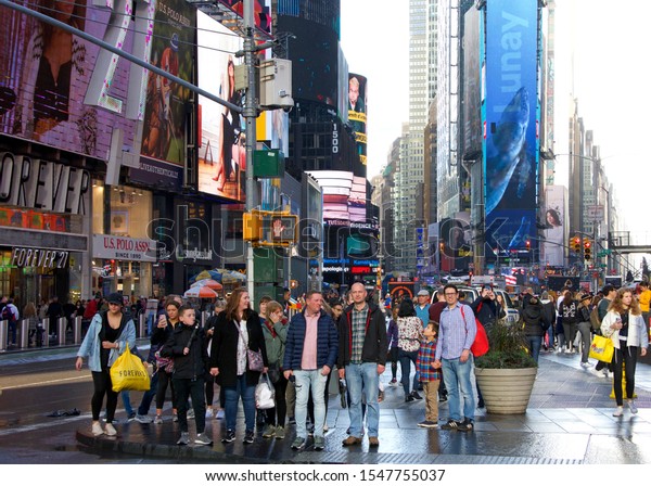New York,\
N.Y. - Oct 27, 2019: Tourists walking up and down Broadway in Time\
Square on a rainy afternoon. A major tourist destination in the\
Midtown Manhattan section of New York\
City