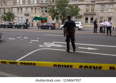 NEW YORK, NY- A Police Officer Stands At The Scene Of A Car Accident On Friday, August 10th. A 23-year-old Woman Was Riding In The Bicycle Lane When She Was Struck And Killed By A Garbage Truck.