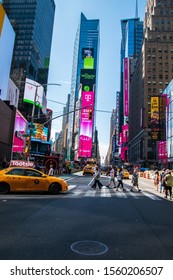 New York, NY - September, 2019: Vertical Street View Of People Crossing Broadway In Times Square. Colorful Billboards Are Seen. Taxis Are On The Avenue