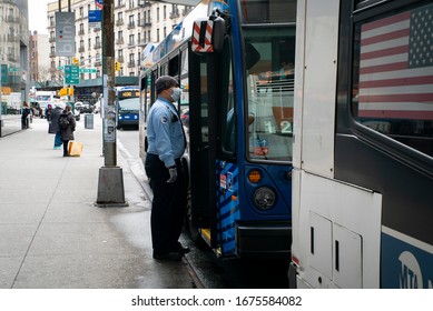 New York, NY / United States - March 17th 2020: A Metro Transit Authority Worker Wears A Surgical Mask While Speaking A Driver On A New York City Bus During The COVID-19 / Coronavirus Pandemic.