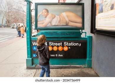 New York, NY, US: March 30, 2018: A Boy Looks At An Ad On A NYC Subway Stairwell