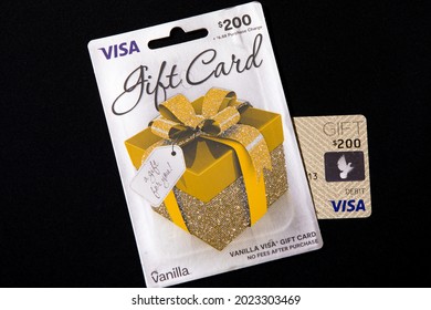 New York, NY, USA 8-9-2021: Vanilla Visa gift card in $200 denomination before purchase fee, the highest amount available at stores. Gold present box with ribbon illustration on package envelope.