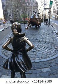 New York, NY, USA April 22, 2018 Defiant Girl, A Sculpture By Kristen Visbal, Stares Down The Wall Street Bull In New York's Financial District