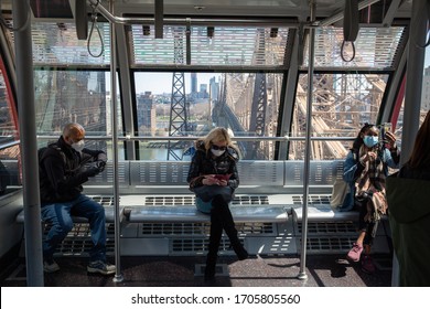 New York, NY/ USA - April 16 2020: Two Women And One Man Wearing Medical Face Masks In Public In Transport With The Queensboro Bridge In The Window. 
