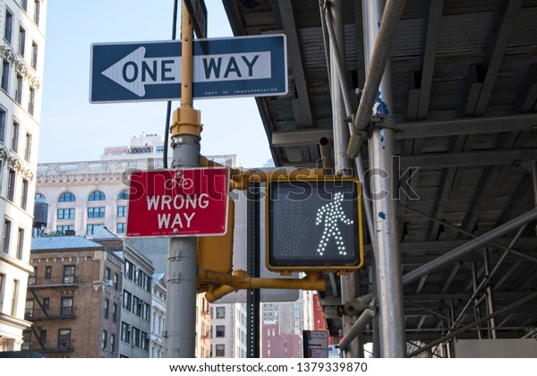 New York, NY, USA - April 22, 2019: An\
intersection on Fifth Avenue shows a collection of signs pertaining\
to cars, bicycles and\
pedestrians.