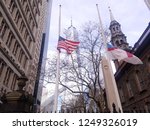 New York, NY / USA- December 3 2018: United States flag and Episcopal flag flying half mast in memoriam for President George H. W. Bush in St. Paul