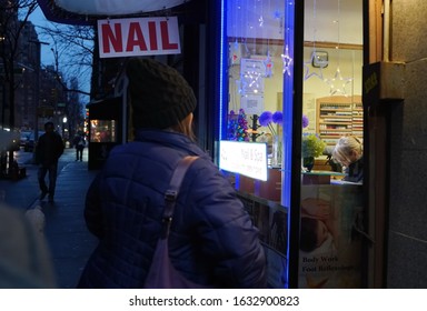 New York, NY / USA - December 29, 2019: Bundled Woman Prepares To Treat Herself And Walk Into A Nail Salon After Work