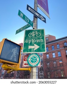 New York, NY USA - February 22, 2020 : Green New York City street signs showing one way uptown bicycle bike path on St. Nicholas Avenue and W 119th Street in Harlem, USA
