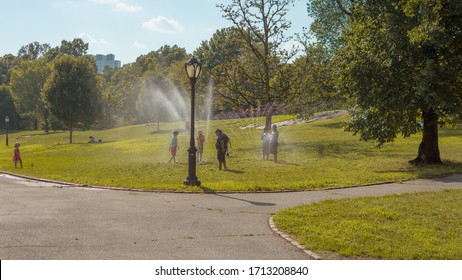 New York, NY, USA - July 21, 2019: Children Playing In Sprinklers In Central Park During Heat Wave