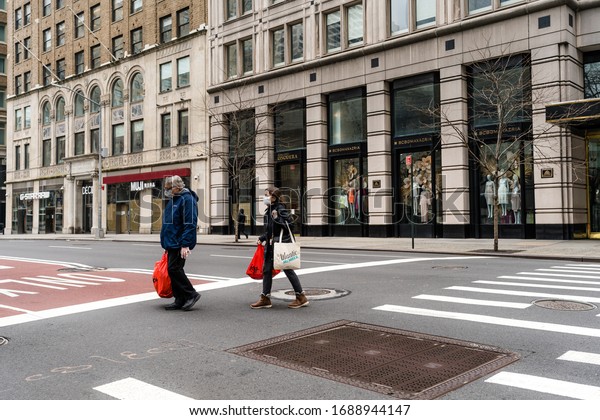 New\
York, NY / USA - March 16 2020: old man and woman crossing empty\
street during coronavirus pandemic city\
lockdown