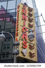 New York, NY - USA - May 20, 2022 Vertical view of Times Square Junior's Restaurant's neon Sign. The Brooklyn-themed landmark located near the corner of Broadway and 45th St., is known for cheesecake.