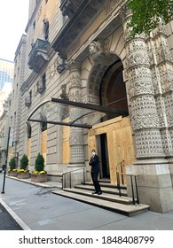 New York, NY/ USA - November 4, 2020: Doorman In Front Of Boarded Up Entance In Manhattan During The Covid-19 Pandemic And Election Uncertainty