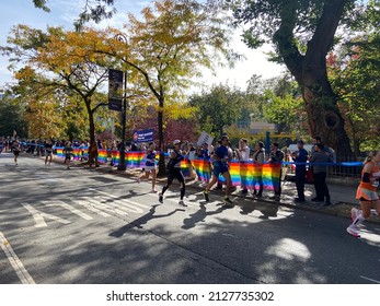 New York, NY USA - November 7, 2021 - Runners pass by an LGBT Pride rainbow flag in Harlem during the 2021 TCS New York City Marathon in New York on November 7, 2021