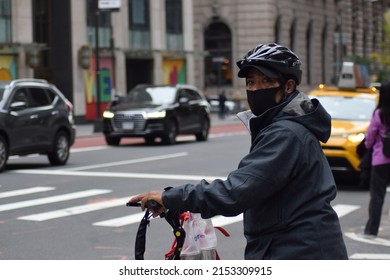 New York, NY  USA - November 8, 2020: New York City, Masked Bicycle Delivery Person On Fifth Avenue During Covid-19 Pandemic