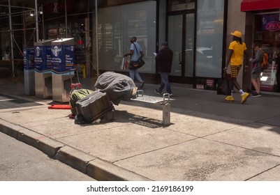 New York NY USA-June 18, 2022 A Homeless Man Sleeps On A Bench At A Bus Stop In New York