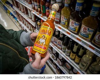 New York NY USA-November 24, 2020 A Discerning Shopper Chooses A Bottle Of Cholula Brand Hot Sauce In A Supermarket In New York