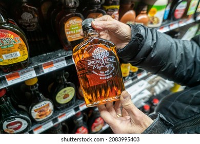 New York NY USA-November 30, 2021 A shopper selects a bottle of maple syrup, a blend of USA and Canadian syrups, in a supermarket in New York