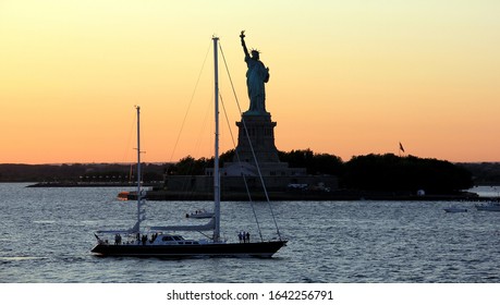 New York, NY/USA - September 12, 2012: Sailing boat passing the Statue of Liberty at sunset