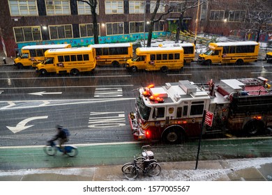 New York NY/USA-December 2, 2019 School buses line up in the snow in front of PS 33 in Chelsea in New York in anticipation of dismissal