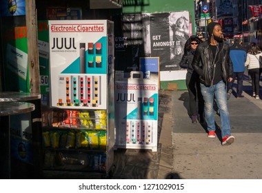 New York NY/USA/-December 29, 2018 Passer-by In The Tribeca Neighborhood Of New York Walk Past A Store Advertising Juul Brand Vaping Products.