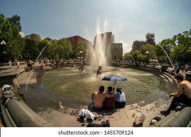 New York NY/USA-July 19, 2019 New Yorkers and visitors frolic in the fountain in Washington Square Park in Greenwich Village in New York