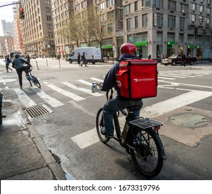 New York NY/USA-March 13, 2020 A delivery person with a DoorDash branded tote on his bicycle in the Chelsea neighborhood of New York