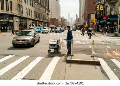 New York NY/USA-March 20, 2020 A Masked USPS Mail Carrier Crosses Sixth Avenue In New York